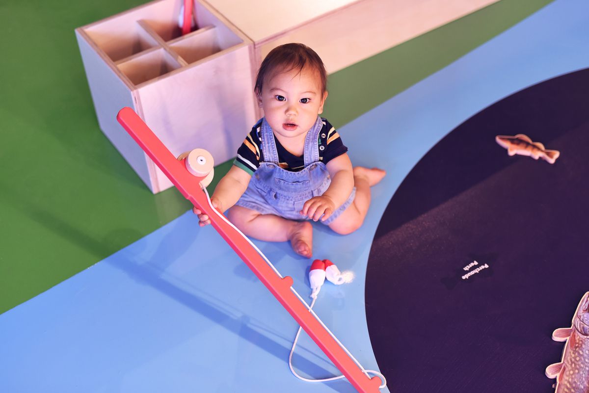 An infant at the Mini Mondo exhibit looks directly at the camera