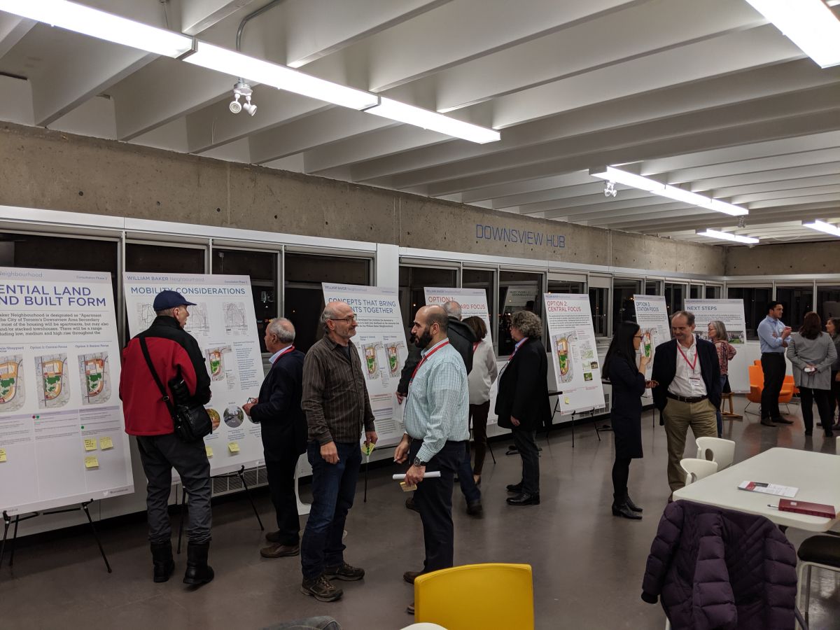 A group of people review a series of presentation boards