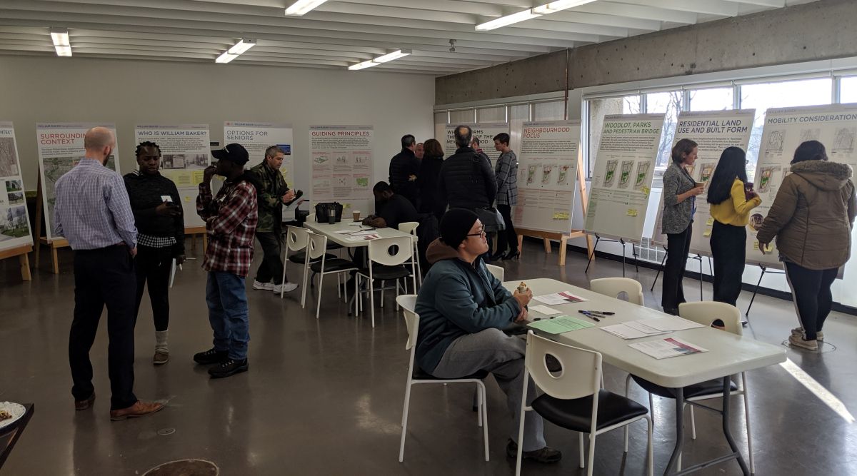 A group of people review a series of presentation boards