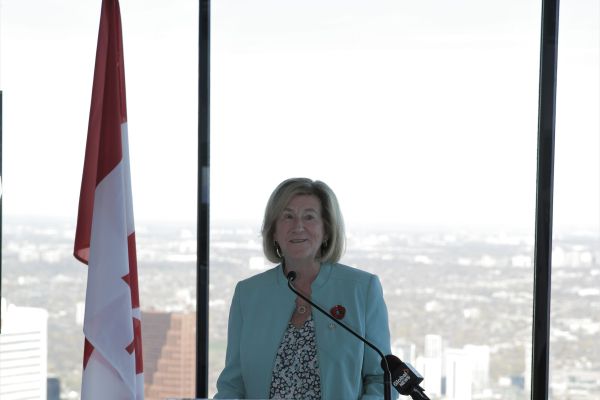 Flag and Minister Helena Jaczek at a podium
