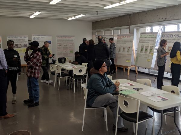 A group of people review a series of presentation boards